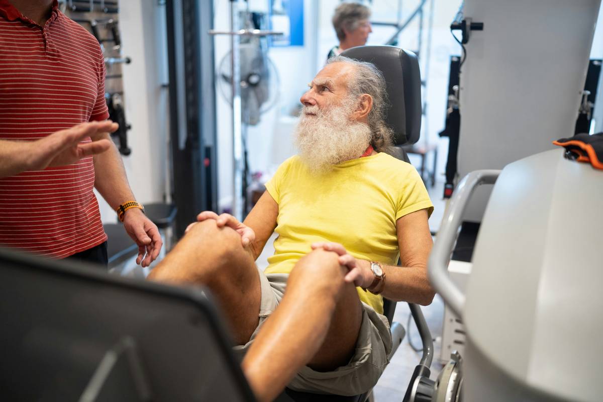 Middle-aged man stretching post-workout during recovery over fitness at home workout session